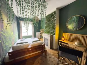 una camera da letto con un letto grande e uno specchio di Jungle Urbain- Sauna - Ciné - Hamac - Hyper centre ad Amiens