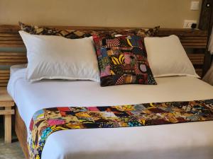 a bed with a comforter and two pillows at Haradali's Home in Arusha