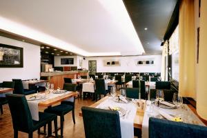 a dining room with tables and chairs in a restaurant at Elite in Visp