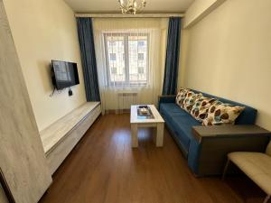un soggiorno con divano blu e TV di Apartments by GR Yerevan in the city centre a Yerevan