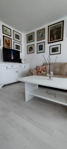 a living room with a white table and pictures on the wall at Royal Apartment Bar in Bar
