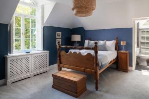 - une chambre avec un lit et un mur bleu dans l'établissement The Cors Country House, à Laugharne