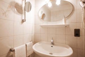 a white bathroom with a sink and a mirror at B&B Hotel Mair am Turm in Tirolo +52 photos