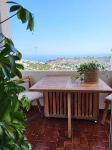 a wooden table on a balcony with a view of the ocean at Studio Apartment with Sea View & Fibre Internet in Albufeira