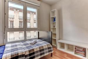 um quarto com uma cama e uma grande janela em Le Charlemagne- Boulogne em Boulogne-Billancourt