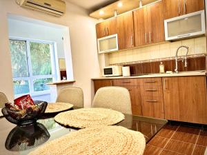 eine Küche mit einem Glastisch, Stühlen und einer Theke in der Unterkunft Cozy Place to Stay -Self check in 24h in Reşiţa