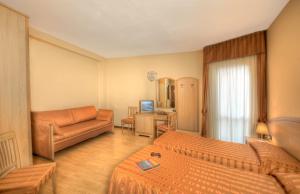 バヴェーノにあるHotel Residence Dei Fioriのベッド2台とソファが備わるホテルルームです。