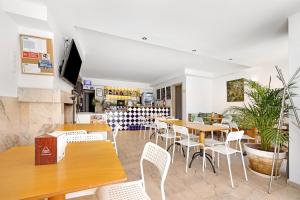 een restaurant met houten tafels en witte stoelen bij Solemcabana - Sunny Villa Flat 101 in Lagos