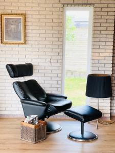 two black leather chairs and a lamp in a room at Scandinavian House Hotel- Holbøl, Kruså in Kruså