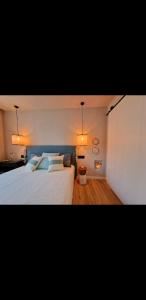 een slaapkamer met een groot wit bed en 2 verlichting bij Villa Bonica in Palamós