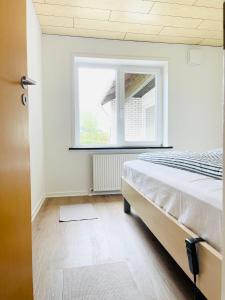 een slaapkamer met een bed en een raam bij Scandinavian House Hotel- Holbøl, Kruså in Kruså