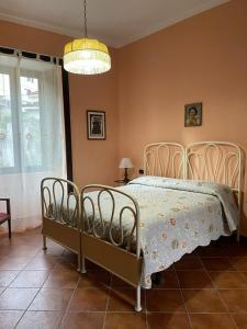 1 dormitorio con cama y lámpara de araña en B&B Villa Rachele, en Casaletto Spartano