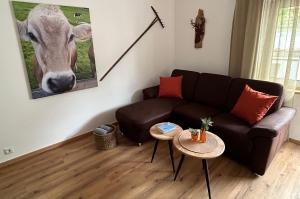 een woonkamer met een bank en een foto van een koe bij Ferienwohnung Immerschön in Pfronten