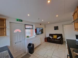 a living room with a door and a couch at Nice Living Serviced Accommodations 8 (Entire 2 Ensuite Bedroom House) in Coventry