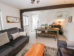 a living room with a couch and a table at Clematis Cottage in Shrewsbury