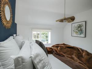 un soggiorno con divano e coperta di Clematis Cottage a Shrewsbury