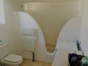 a white bathroom with a toilet and a sink at Paros spacious apartment in Prodromos Paros