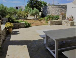 a picnic table in a garden with a stone wall at Paros spacious apartment in Prodromos Paros