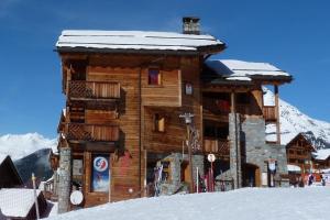 a log cabin with snow on top of it at L'Aiglon - spacious 2-bedroom apartment with log fire in Sainte-Foy-Tarentaise