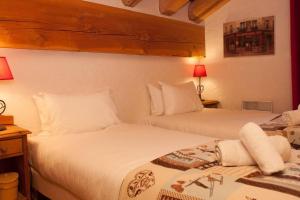 two beds sitting next to each other in a bedroom at L'Aiglon - spacious 2-bedroom apartment with log fire in Sainte-Foy-Tarentaise