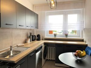 a kitchen with a sink and a bowl of fruit on a table at Apartament ul. Botaniczna in Mielec