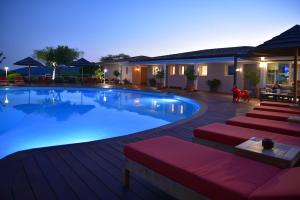 a large swimming pool with red cushioned chairs around it at Hôtel Alivi Di Santa Giulia in Porto-Vecchio