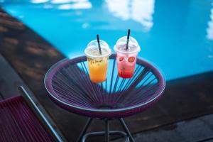 zwei Getränke sitzen auf einem lila Tisch in der Unterkunft Grand Hotel in Kuwait