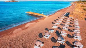 達特恰的住宿－Acroter Hotel Spa - Alcohol Extra All Inclusive，享有海滩的空中景致,配有椅子和遮阳伞