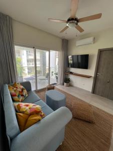 een woonkamer met een bank en een plafondventilator bij Casa Mulata Paseo del Mar Pool & Playa in Punta Cana