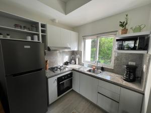 een keuken met witte kasten en een zwarte koelkast bij Casa Mulata Paseo del Mar Pool & Playa in Punta Cana +16 foto's