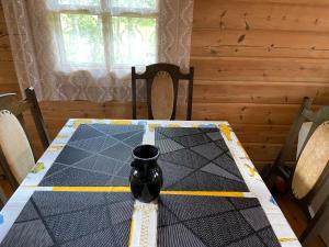 a dining room table with a vase on top of it at Juniper holiday house in Kassari with sauna in Hiiumaa