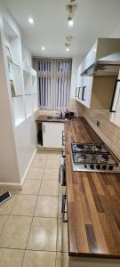a kitchen with white cabinets and a stove top oven at Thorpe House Suites in Heeley