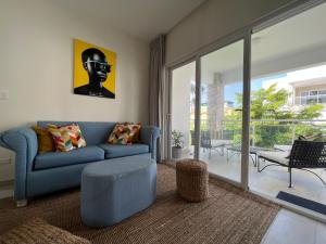 een woonkamer met een blauwe bank en een stoel bij Casa Mulata Paseo del Mar Pool & Playa in Punta Cana