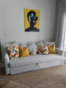 een witte bank met kussens en een foto aan de muur bij Casa Mulata Paseo del Mar Pool & Playa in Punta Cana