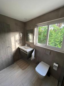 een badkamer met een wastafel en een toilet en een raam bij Casa Mulata Paseo del Mar Pool & Playa in Punta Cana +41 foto's