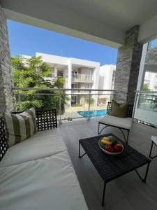 Casa Mulata Paseo del Mar Pool & Playa في بونتا كانا: غرفة معيشة مع أريكة ووعاء من الفواكه على طاولة