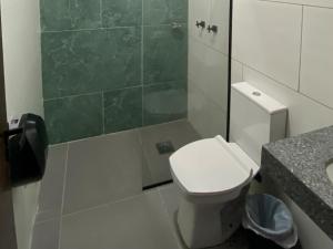 a bathroom with a toilet and a shower and a sink at Chateau Motel Campinas in Campinas