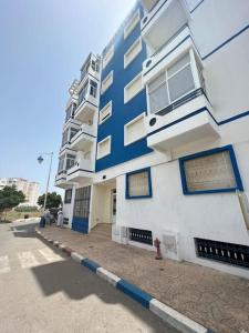 een blauw-wit gebouw met een brandkraan ernaast bij Appartement a louer martil in Martil
