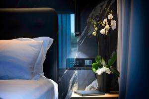 a bedroom with a bed and a window with a vase of flowers at Boutique Hotel Sirmione in Sirmione