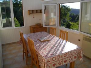a dining room with a table and some windows at Gîte Anould, 3 pièces, 4 personnes - FR-1-589-75 in Anould