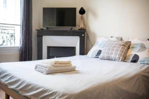 1 dormitorio con 1 cama con toallas en LA BELLE PAUSE - Studio Auxerre proche parking en Auxerre