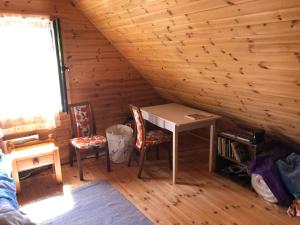 a room with a desk and chairs in a log cabin at Juniper holiday house in Kassari with sauna in Hiiumaa