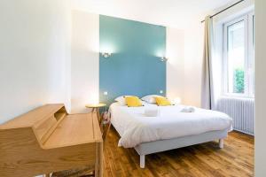 a bedroom with a bed with a desk and a desk at Le Chateaubriand in Dijon