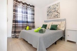 a bedroom with a bed with green pillows on it at Piso Relax - Carpe Mundi in Corralejo