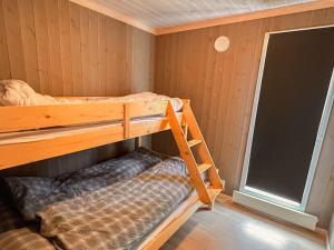 ein kleines Zimmer mit einem Etagenbett und einem Fenster in der Unterkunft Harevadet 211 in Hornindal