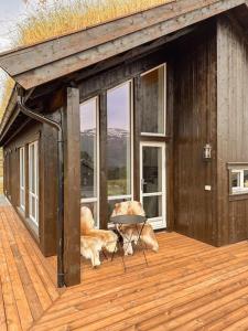 two dogs are sitting on the deck of a house at Harevadet 211 in Hornindal