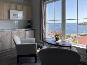 a kitchen with a table and chairs and a large window at Lunenburg Arms Hotel in Lunenburg