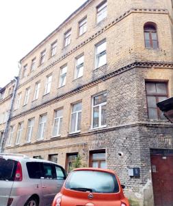 two cars parked in front of a brick building at FREE PARKING Old Town & Central Station Apart with Balcony in Vilnius