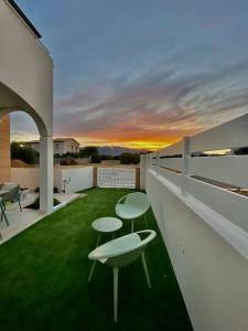 un balcone con due tavoli e sedie sull'erba di Calypso Luxury Pool&Spa a Pula