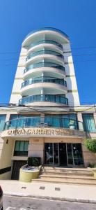 a tall building with a sign on it at Gloria Garden Suites in Macaé